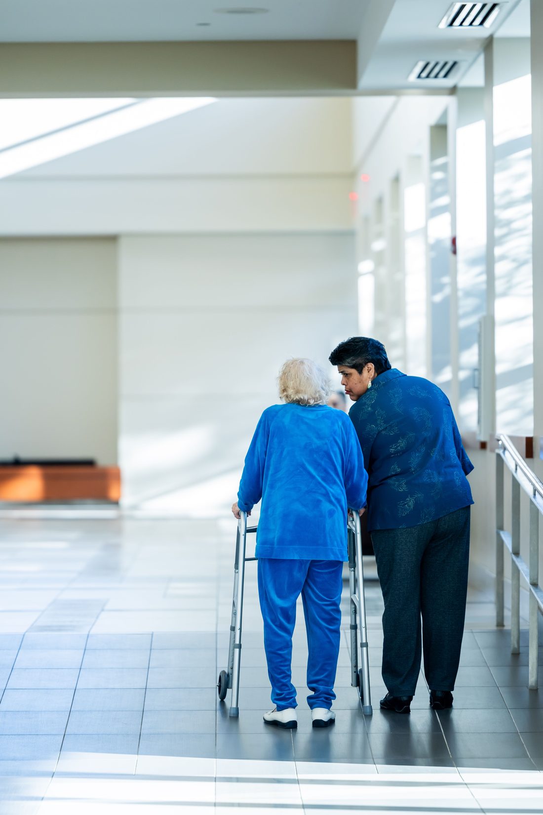 A caregiver walking alongside an older person
